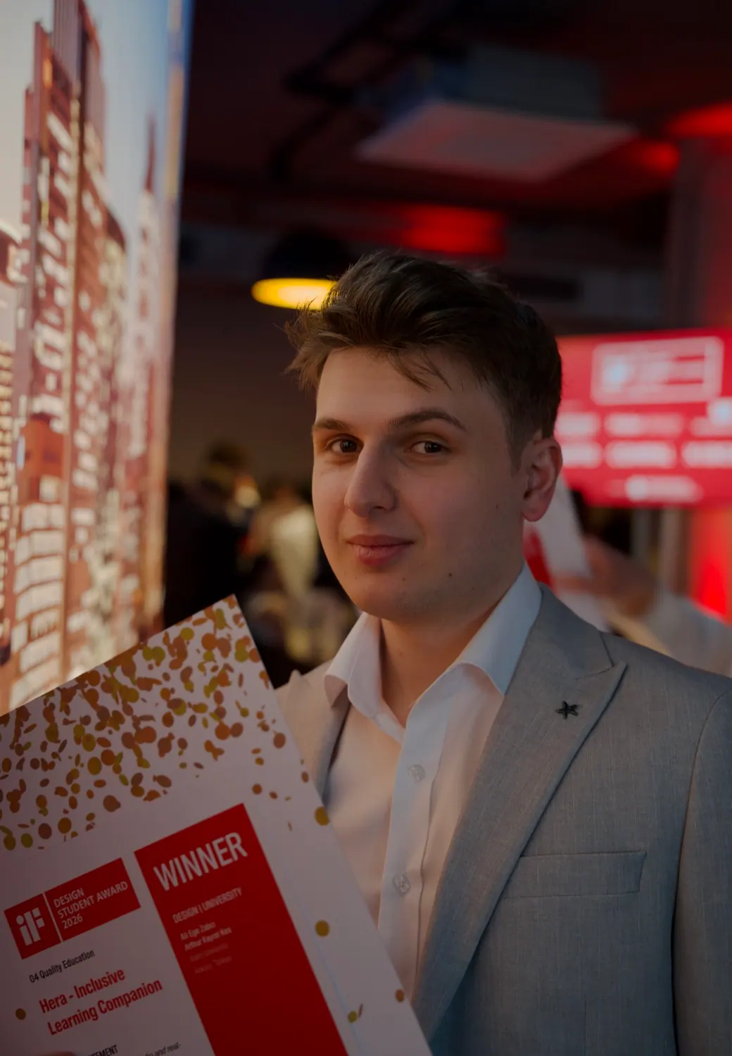 Arthur ve proje arkadaşı iF Design Student Award töreninde sahnede, ellerinde sertifikalarıyla.